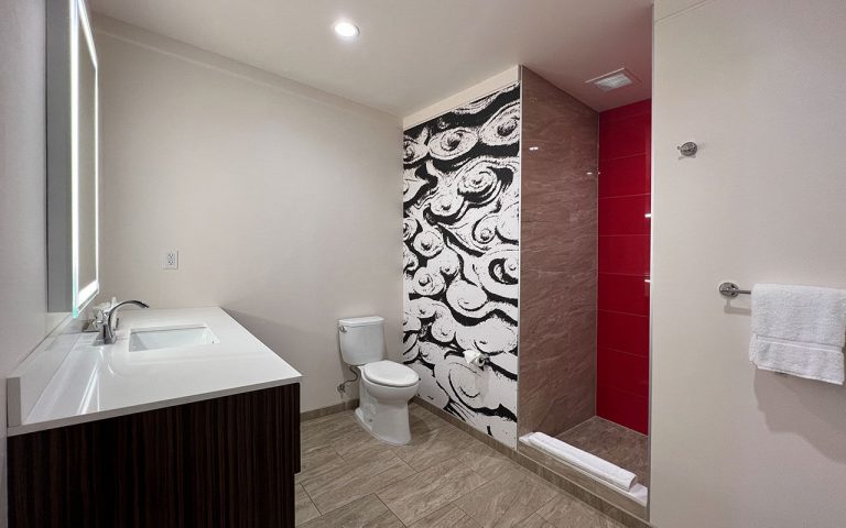 A modern bathroom with a toilet, sink, and shower.